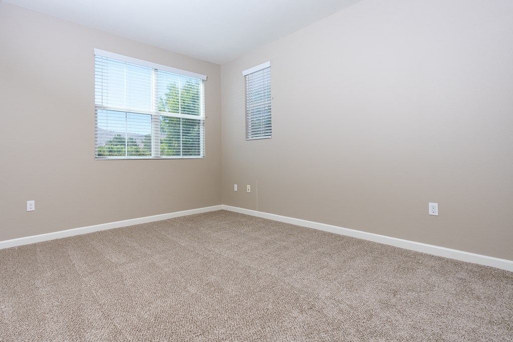 an empty bedroom with a large window