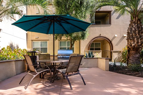 a patio with a table and chairs and an umbrella