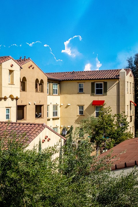 an apartment building with a red door and a blue sky