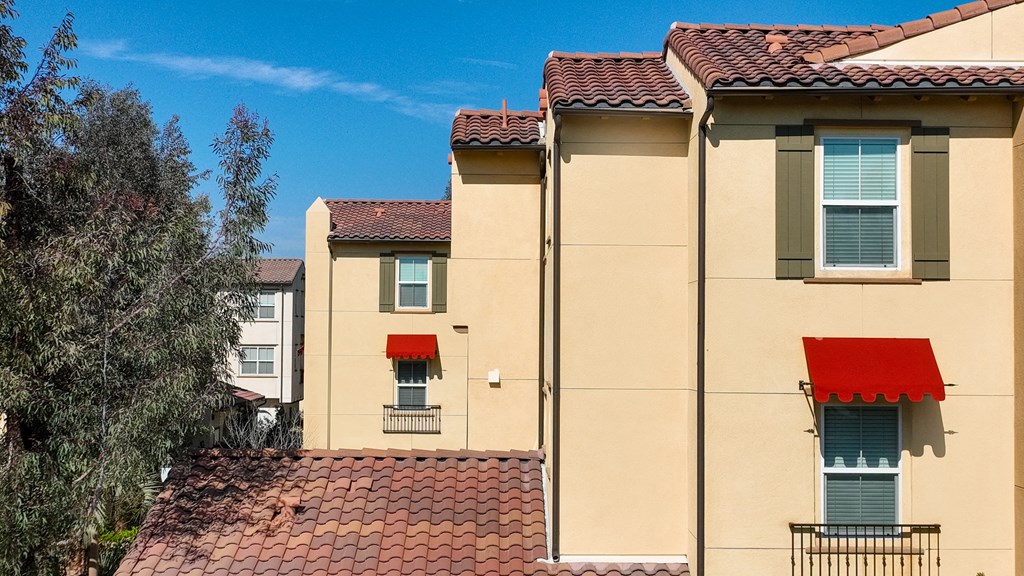 Exterior of  apartment building with red awning over window at Paseos at Magnolia