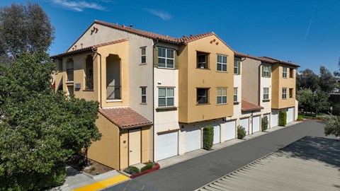 a row of yellow and white apartment buildings on the side of a street