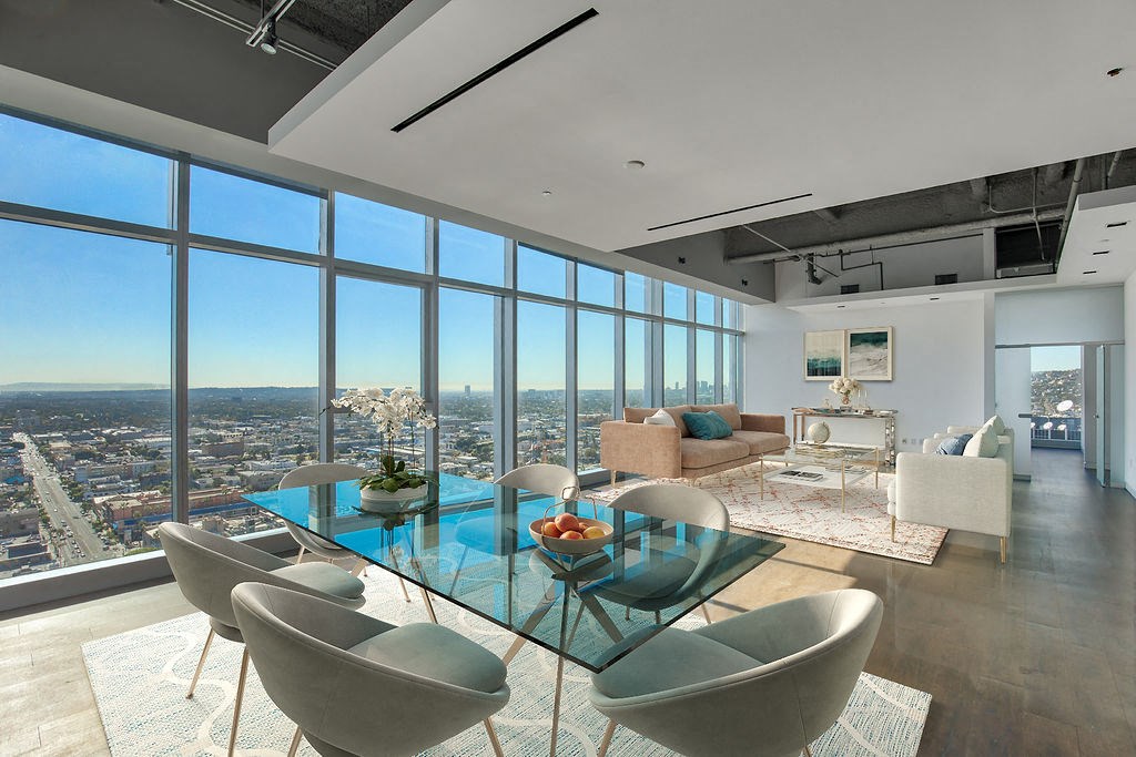 Apartments in Hollywood CA - Open Space Living Room with Hardwood Floors, Stylish Interiors, and Large Windows Showing a View of the City