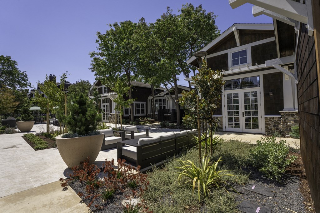 a backyard with a patio and trees and a house