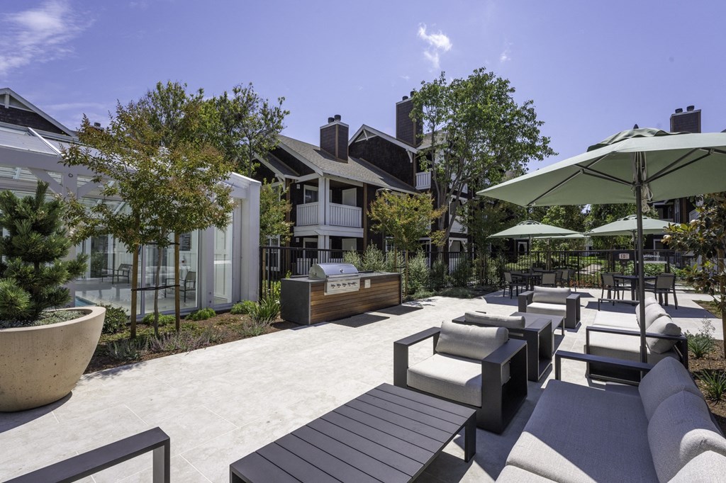a patio area with tables and chairs and umbrellas