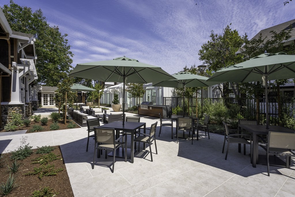 a patio with tables and chairs and umbrellas