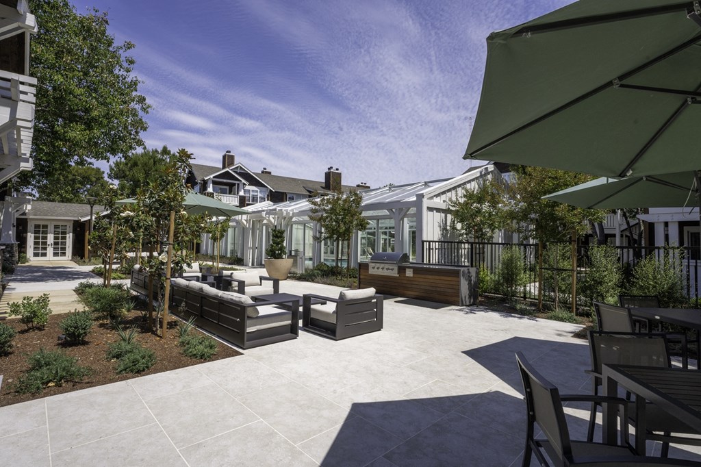 a backyard with patio furniture and umbrellas