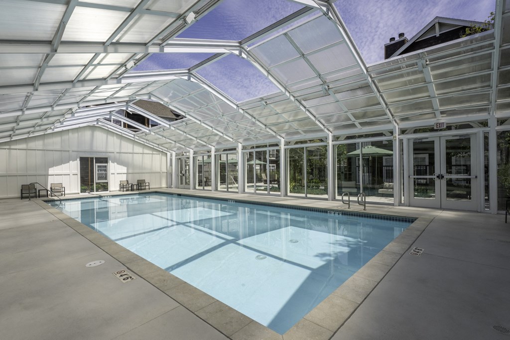 a swimming pool in a glass building with a glass roof