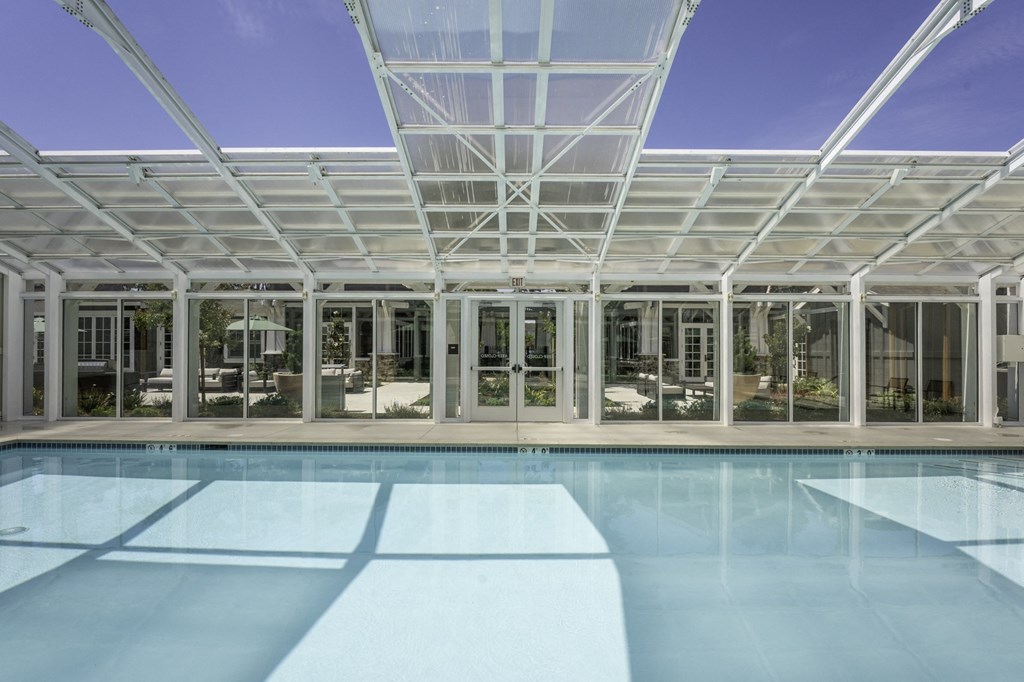 a large pool in front of a glass building
