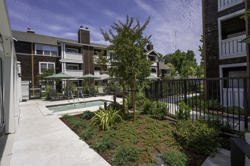 the courtyard of a condo building with a pool and plants