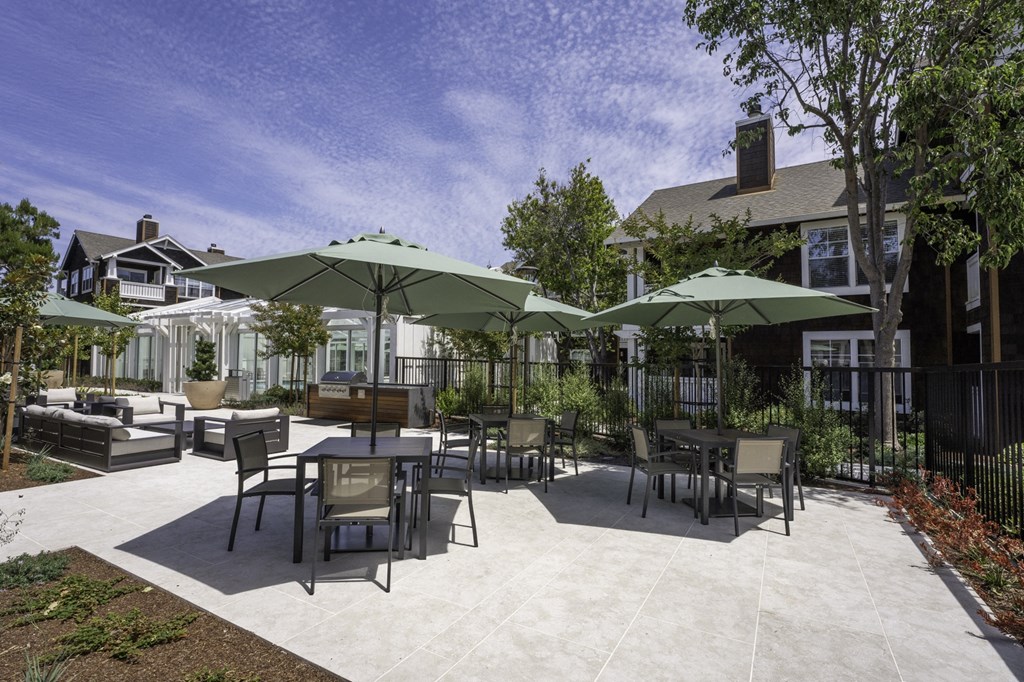 an outdoor patio with tables and chairs and umbrellas
