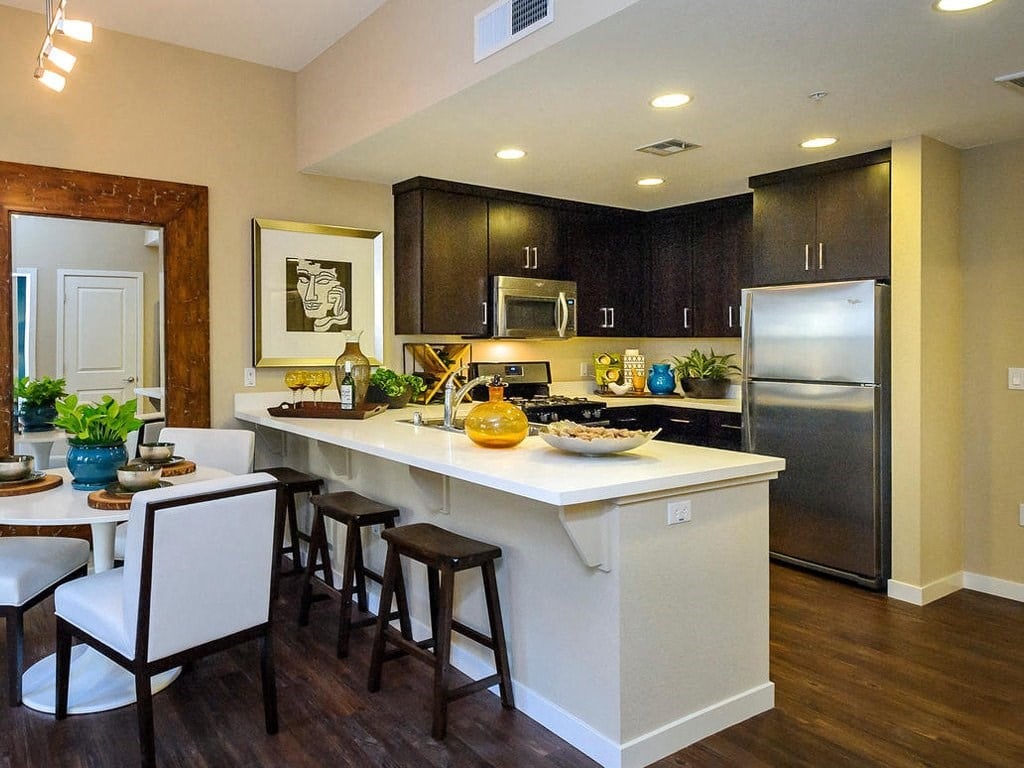 a kitchen with a large counter and a stainless steel refrigerator