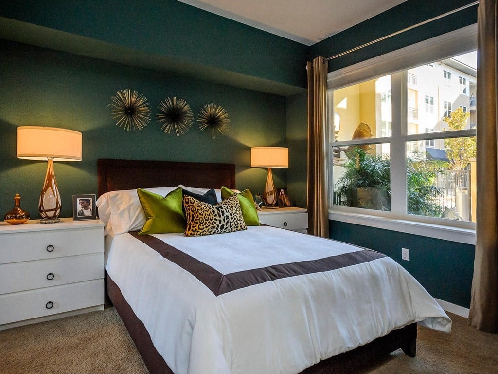 a bedroom with green walls and a white bed