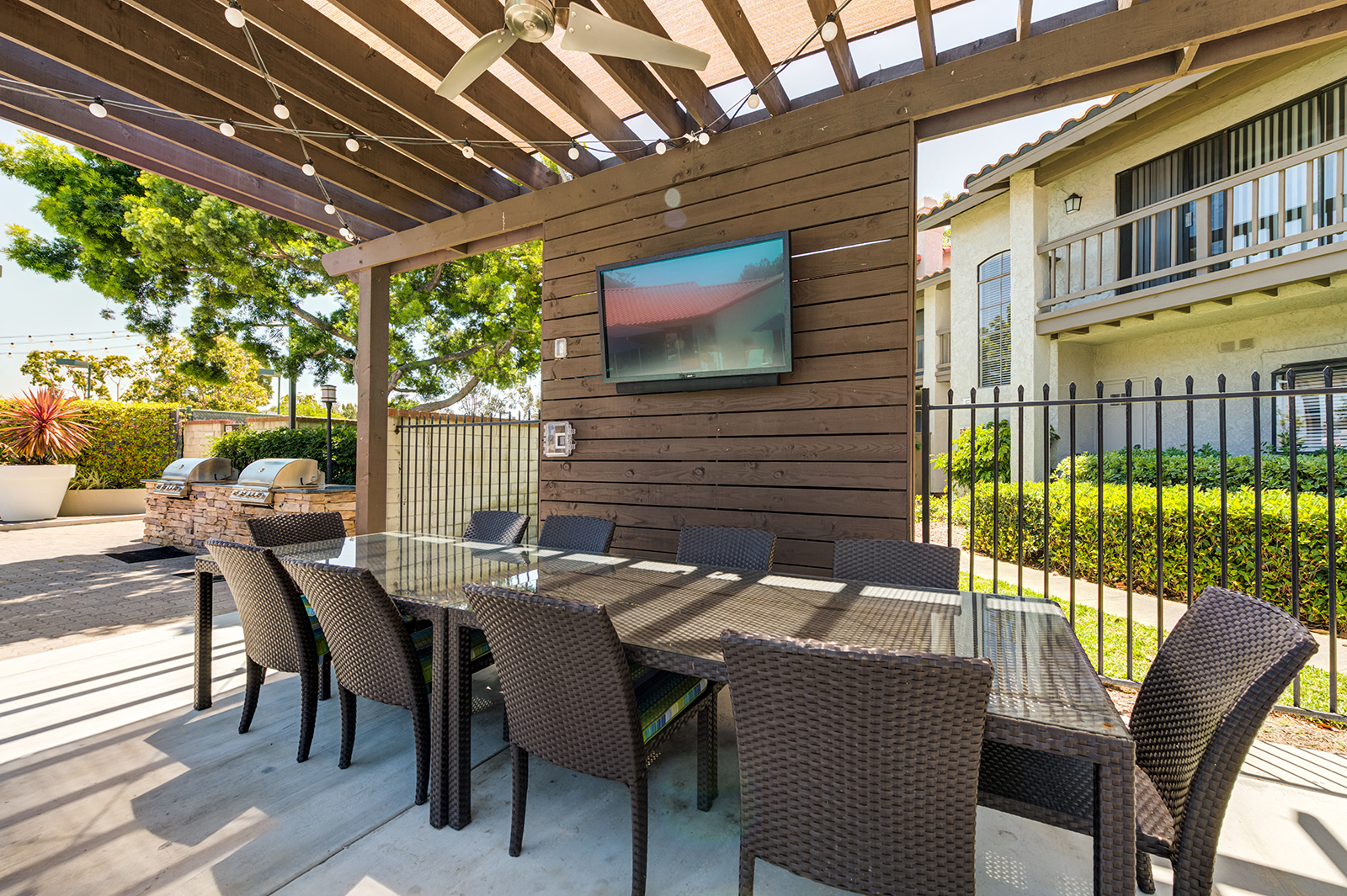 Outdoor dining area and TV adjacent to grill