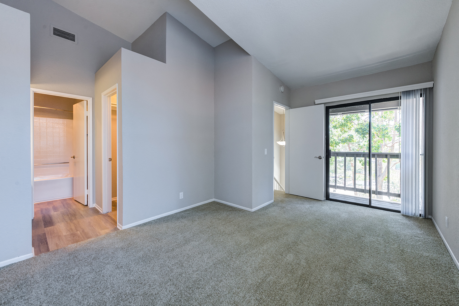 One Bedroom Apartments in Laguna Niguel CA - Pointe Niguel - Empty Bedroom with Carpeted Floor, Gray Walls, and Sliding Glass Door with Access to Balcony