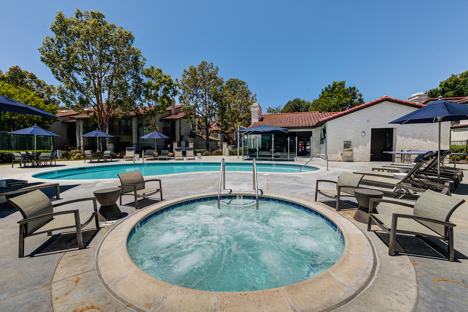 Outdoor pool and jacuzzi area with seating