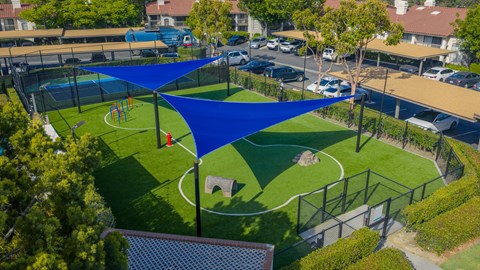 A blue shade structure is over a small soccer field.