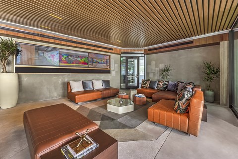 A living room with a brown leather coffee table and orange sofa.