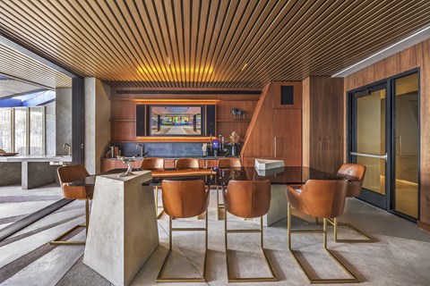 A modern dining room with a wooden ceiling and brown chairs.
