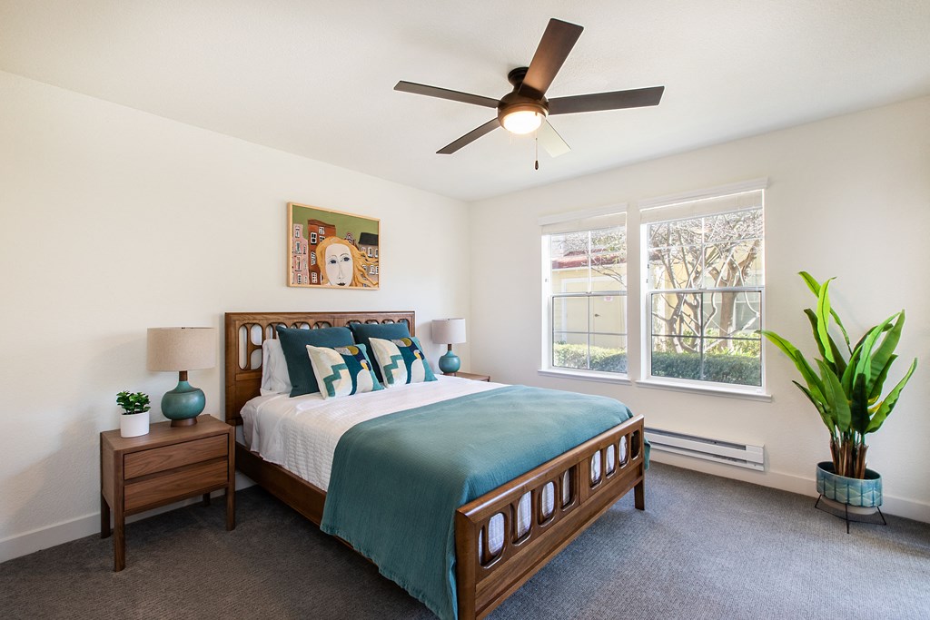 a bedroom with a large bed and a ceiling fan