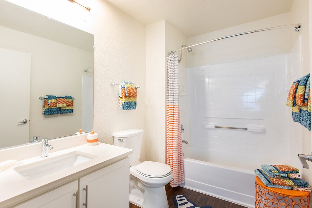 a bathroom with a white sink and toilet and a white tub with a shower curtain