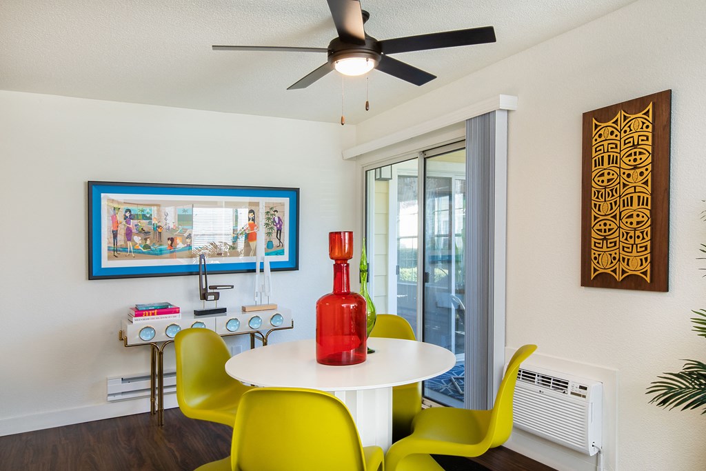 a dining room with a table and chairs and a ceiling fan