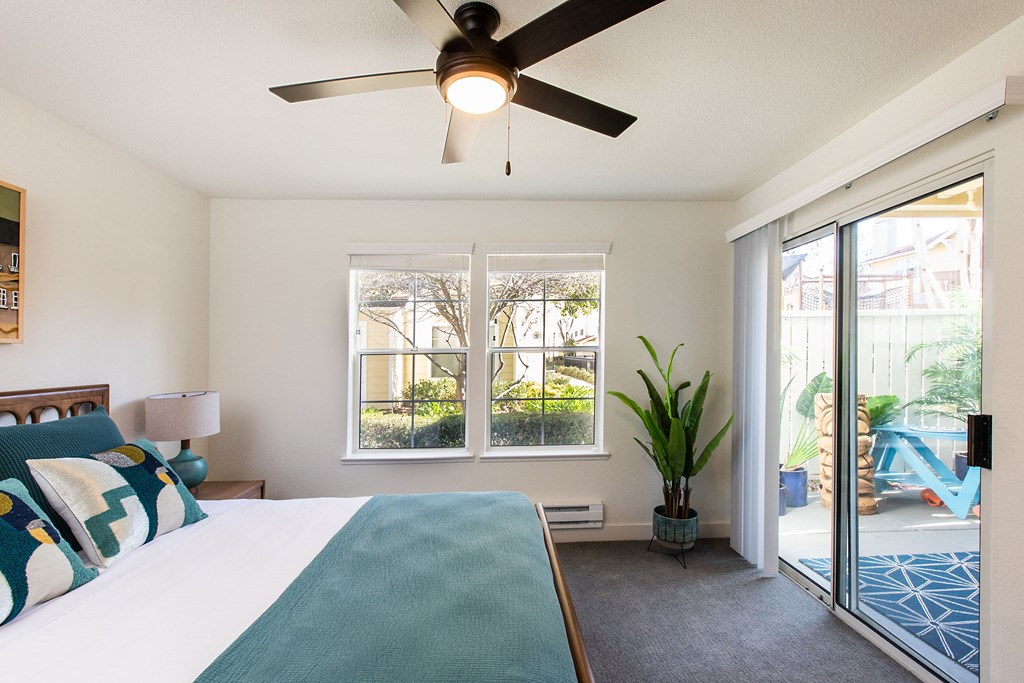 a bedroom with a bed and a ceiling fan