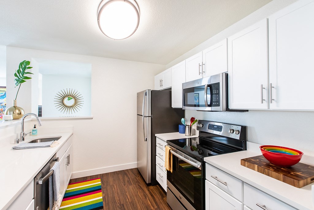 a kitchen with white cabinets and stainless steel appliances