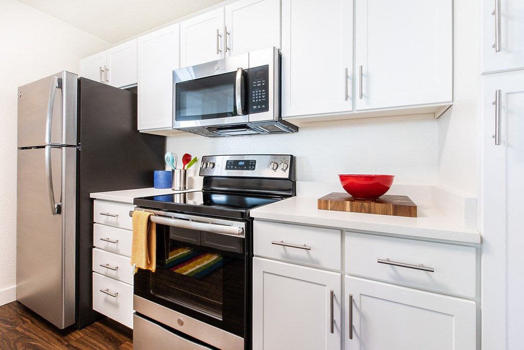 a kitchen with white cabinets and stainless steel appliances