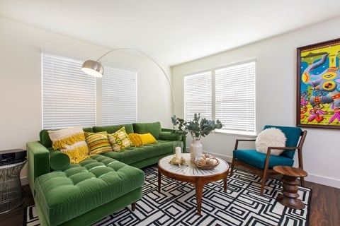 a living room with a green couch and a coffee table