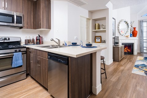A kitchen with a white counter top and wooden cabinets.