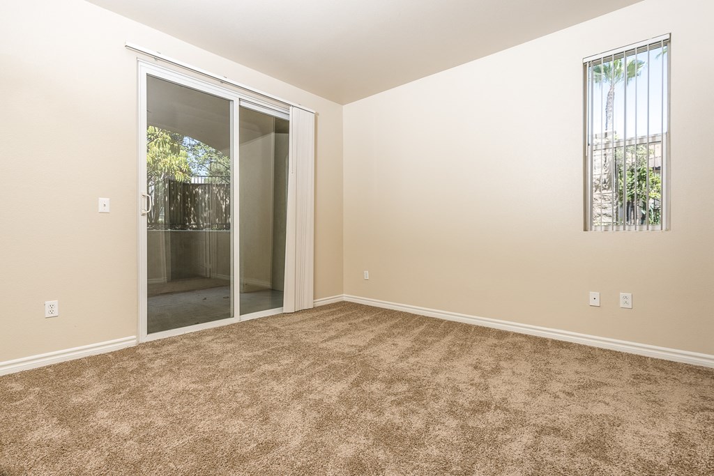 a bedroom with carpet and sliding glass door