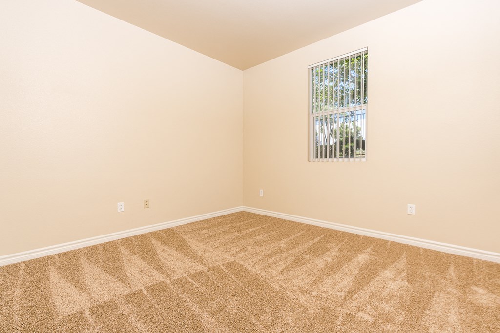 a bedroom with beige walls and carpet