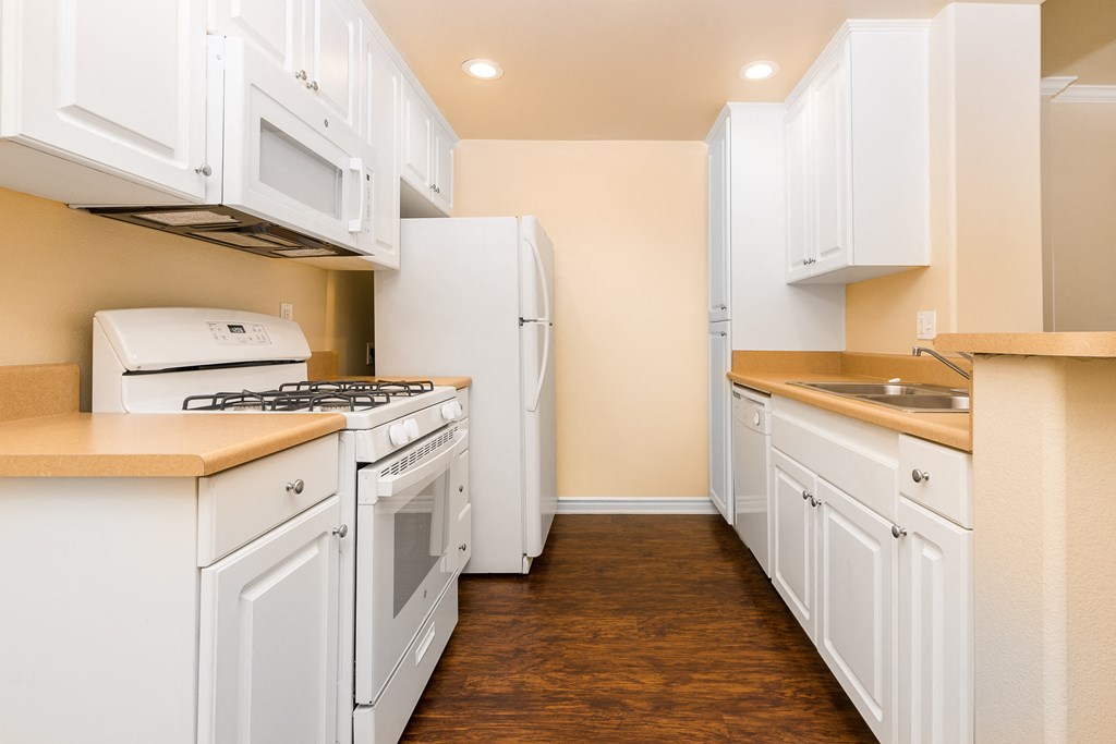 a kitchen with white cabinets and white appliances