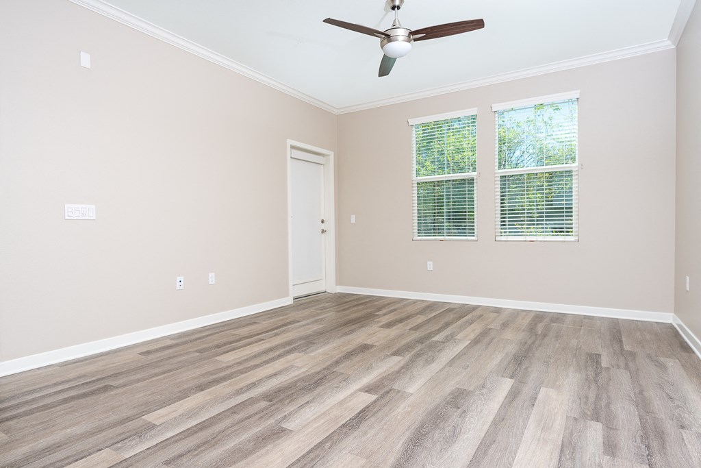 a bedroom with hardwood floors and a ceiling fan