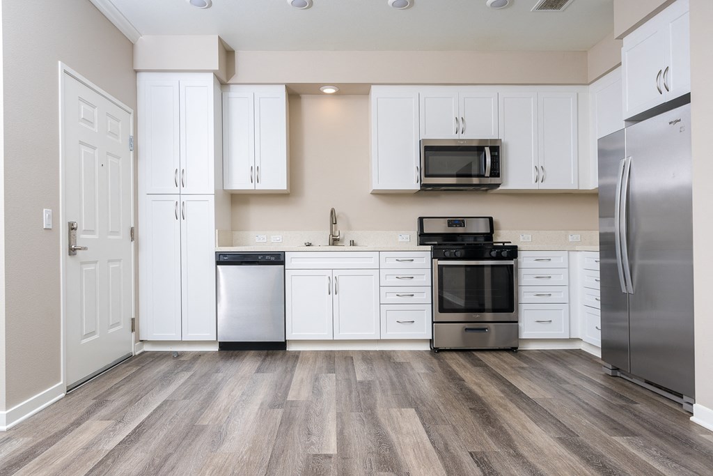 a kitchen with white cabinets and stainless steel appliances