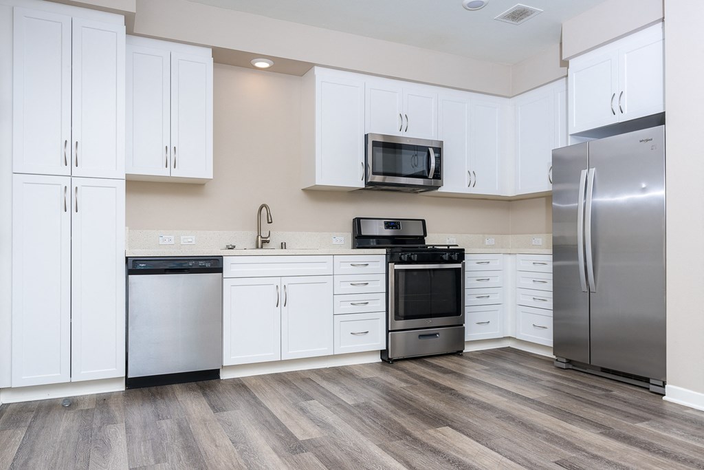 a kitchen with white cabinets and stainless steel appliances