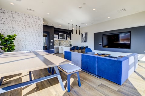 A modern living room with a blue couch and a television.