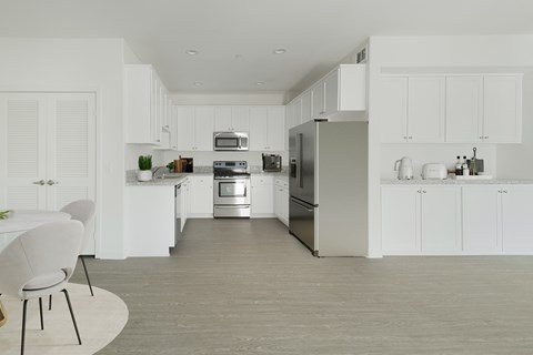 A modern kitchen with white cabinets and stainless steel appliances.