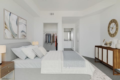 A bedroom with a large bed and a clock on the wall.