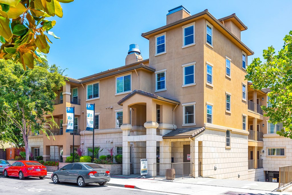 an apartment building with cars parked in front of it
