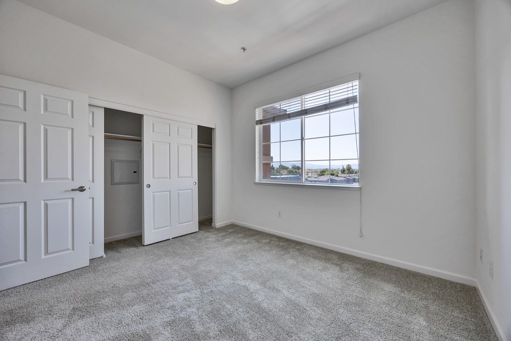 an empty living room with white walls and a window