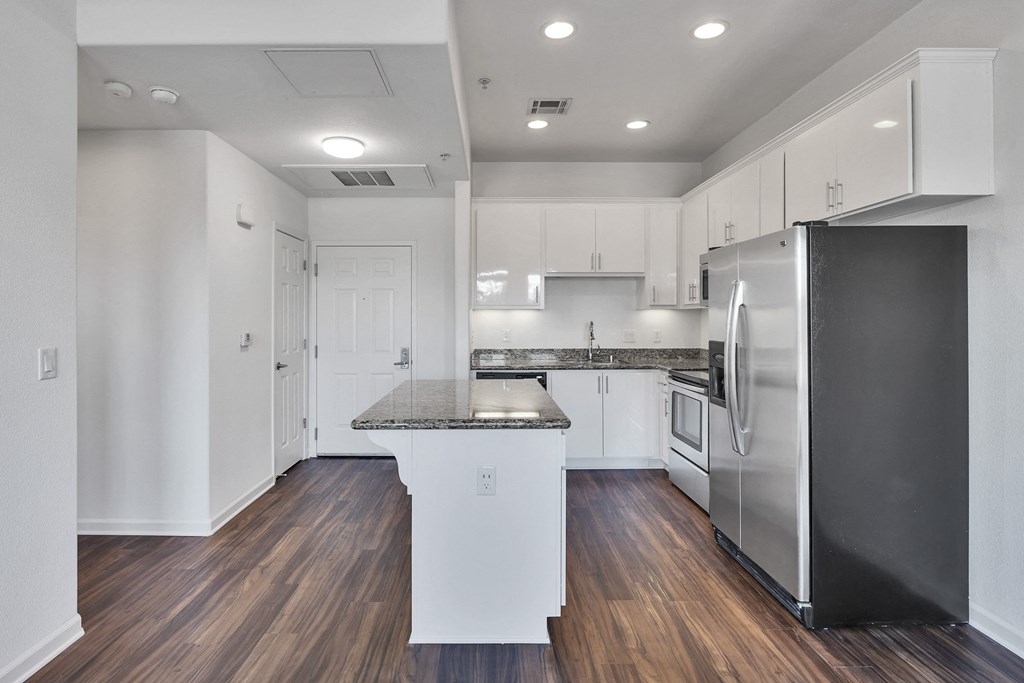 a renovated kitchen with white cabinets and stainless steel appliances