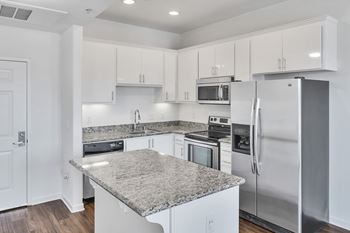 a kitchen with white cabinets and stainless steel appliances and granite counter tops