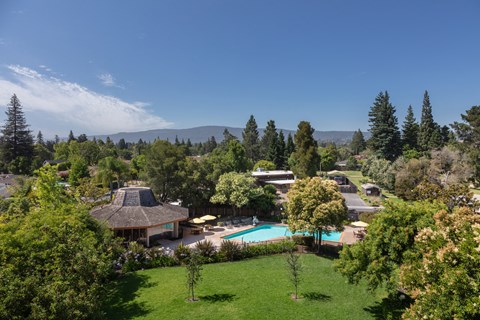 View of grass field and fenced pool area