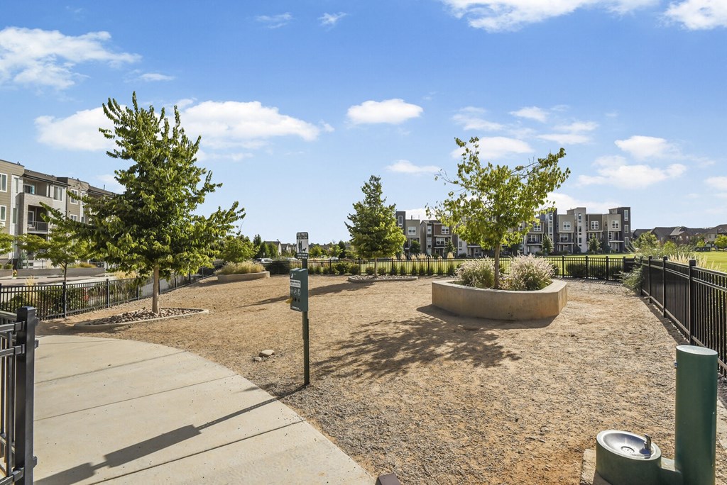 a park with trees and a fence and a city in the background at Parkside at Littleton Village, Colorado, 80122