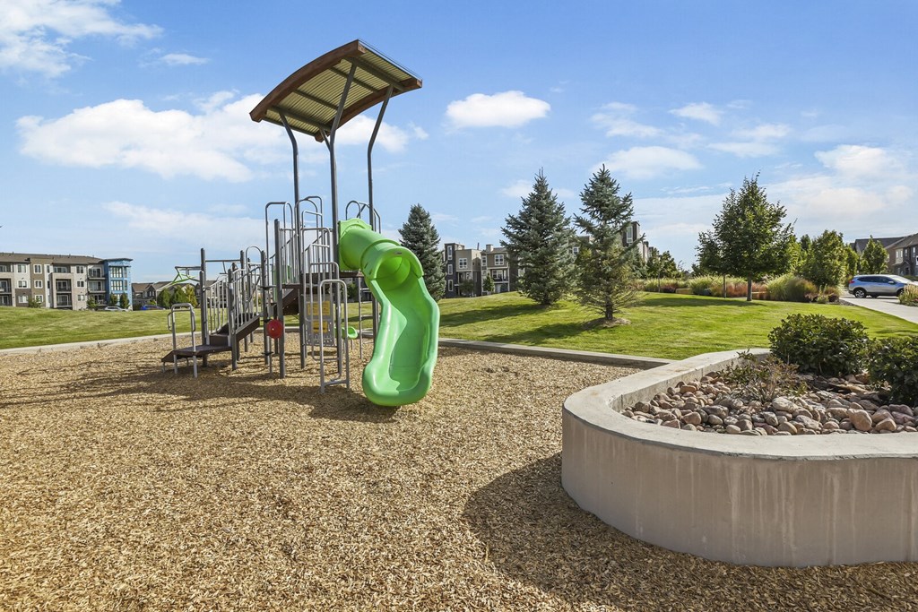 a playground in a park with a large green slide at Parkside at Littleton Village, Colorado, 80122