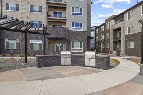 an outdoor kitchen with two stoves in front of an apartment building at Parkside at Littleton Village, Littleton, CO
