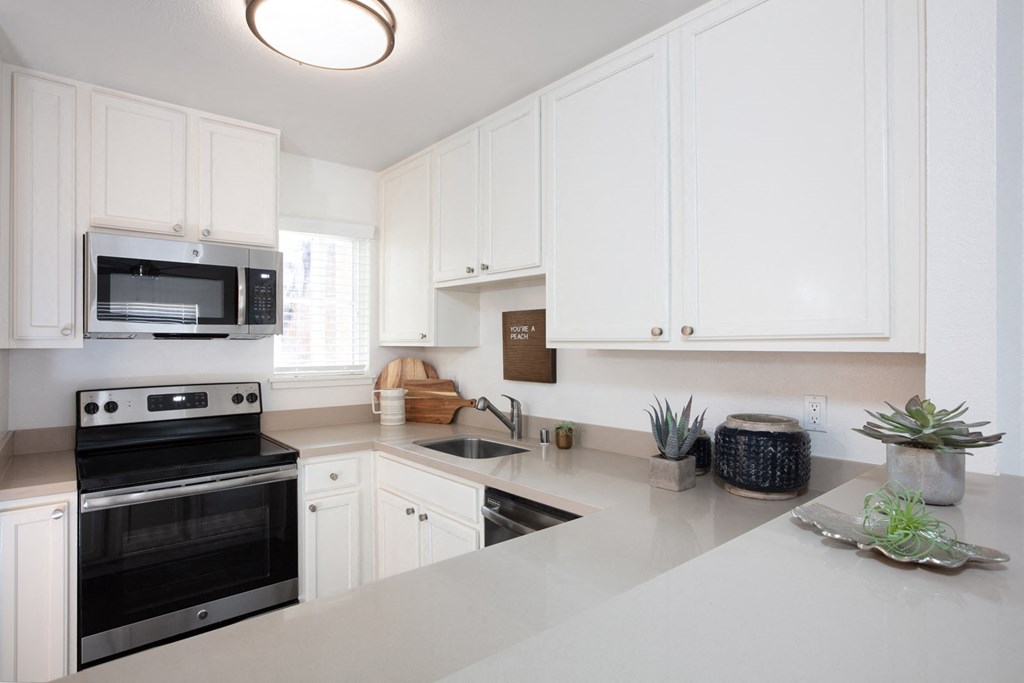 A kitchen with white cabinets and a black stove top oven.
