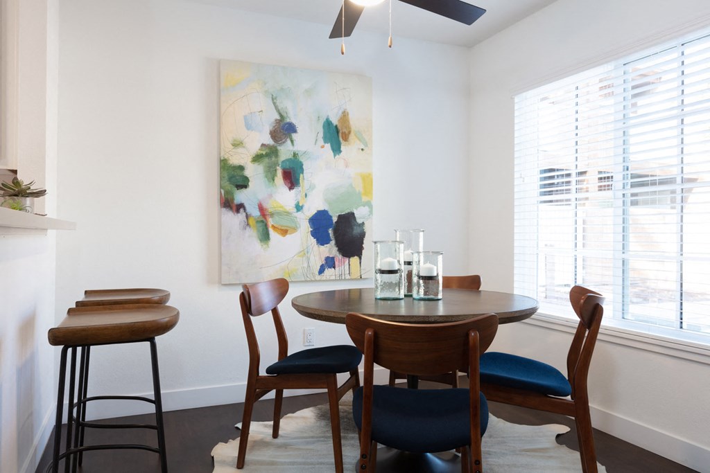 A dining room with a table and chairs.