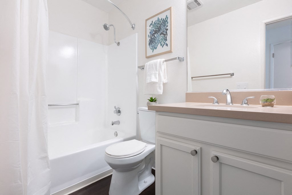 A white toilet sits in a bathroom next to a sink.